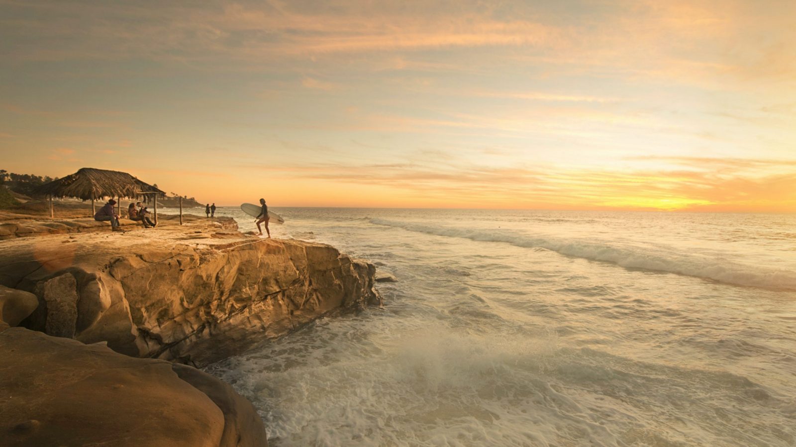 person holding surfboard near body of water